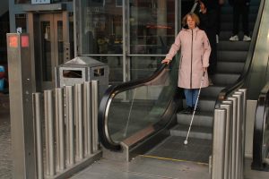 Inge met stok van roltrap