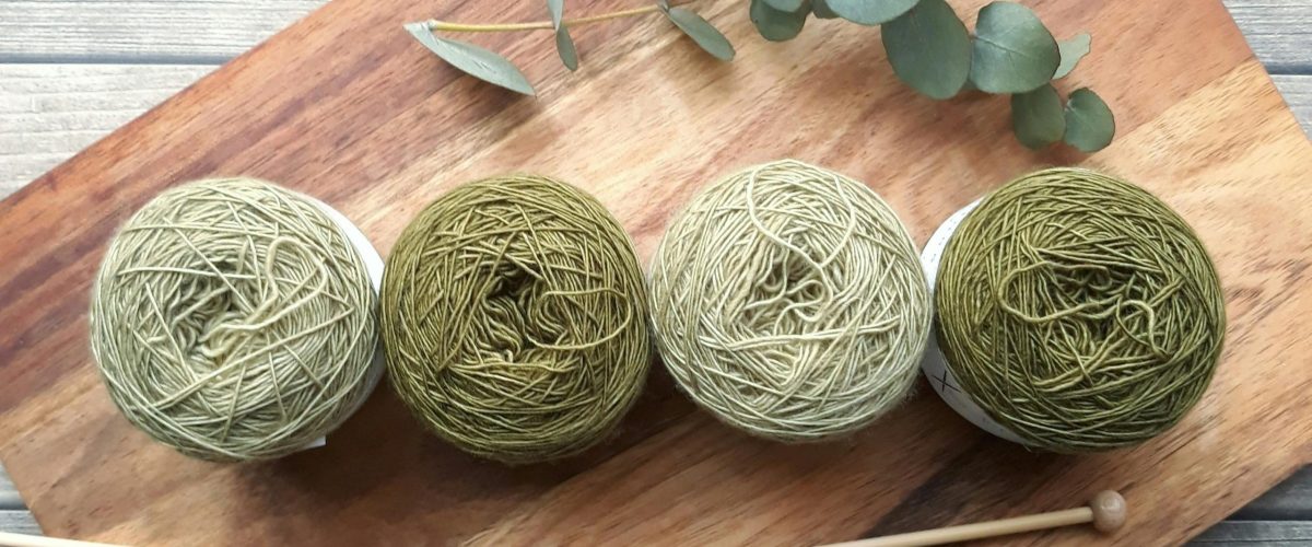 breinaalden en wol in groene tinten